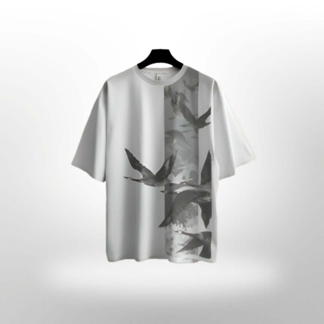 Casual setting with model lounging in a Flying Flamingo oversized T-shirt at a beachside cafe.