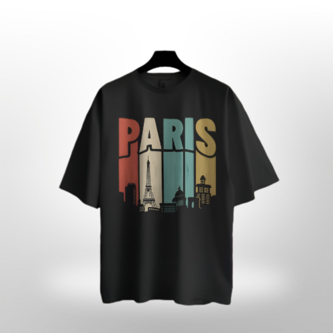 Casual streetwear style featuring oversized T-shirt with PARIS design, worn at a trendy urban café.