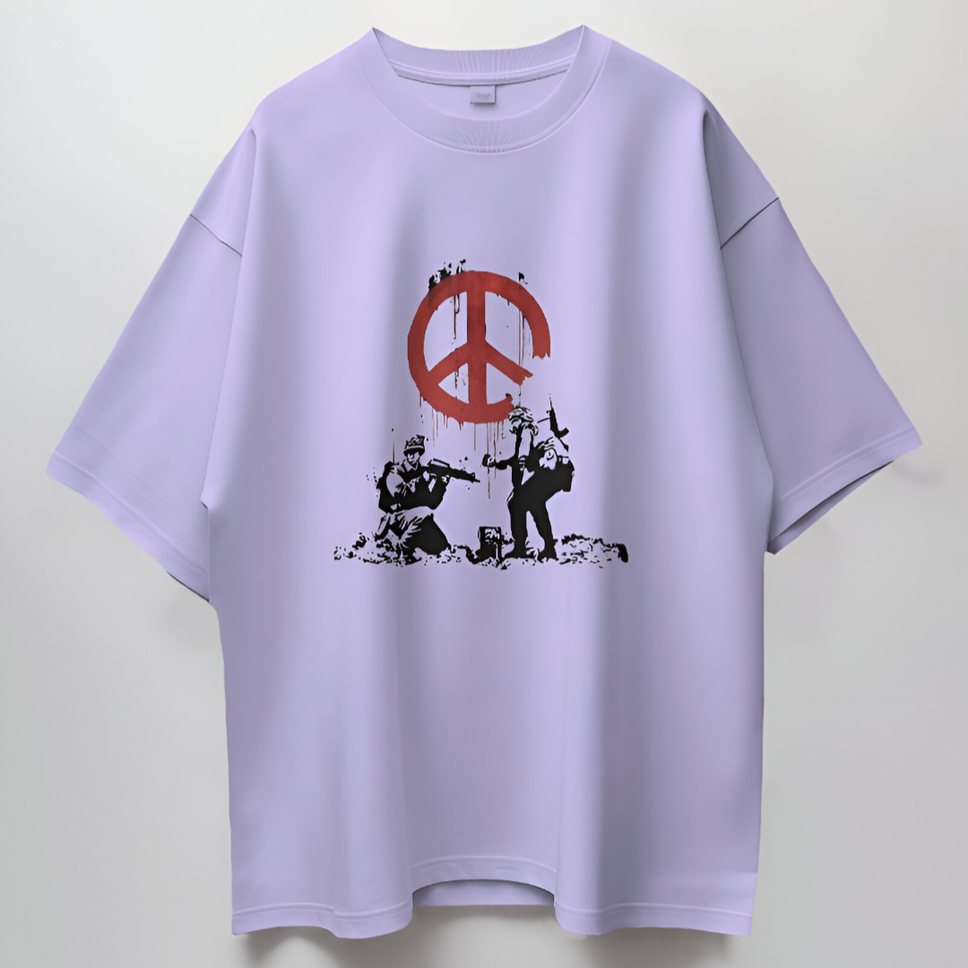 Detailed view of 'Peace in War' text and accompanying peace symbol layered over camo print on olive T-shirt.