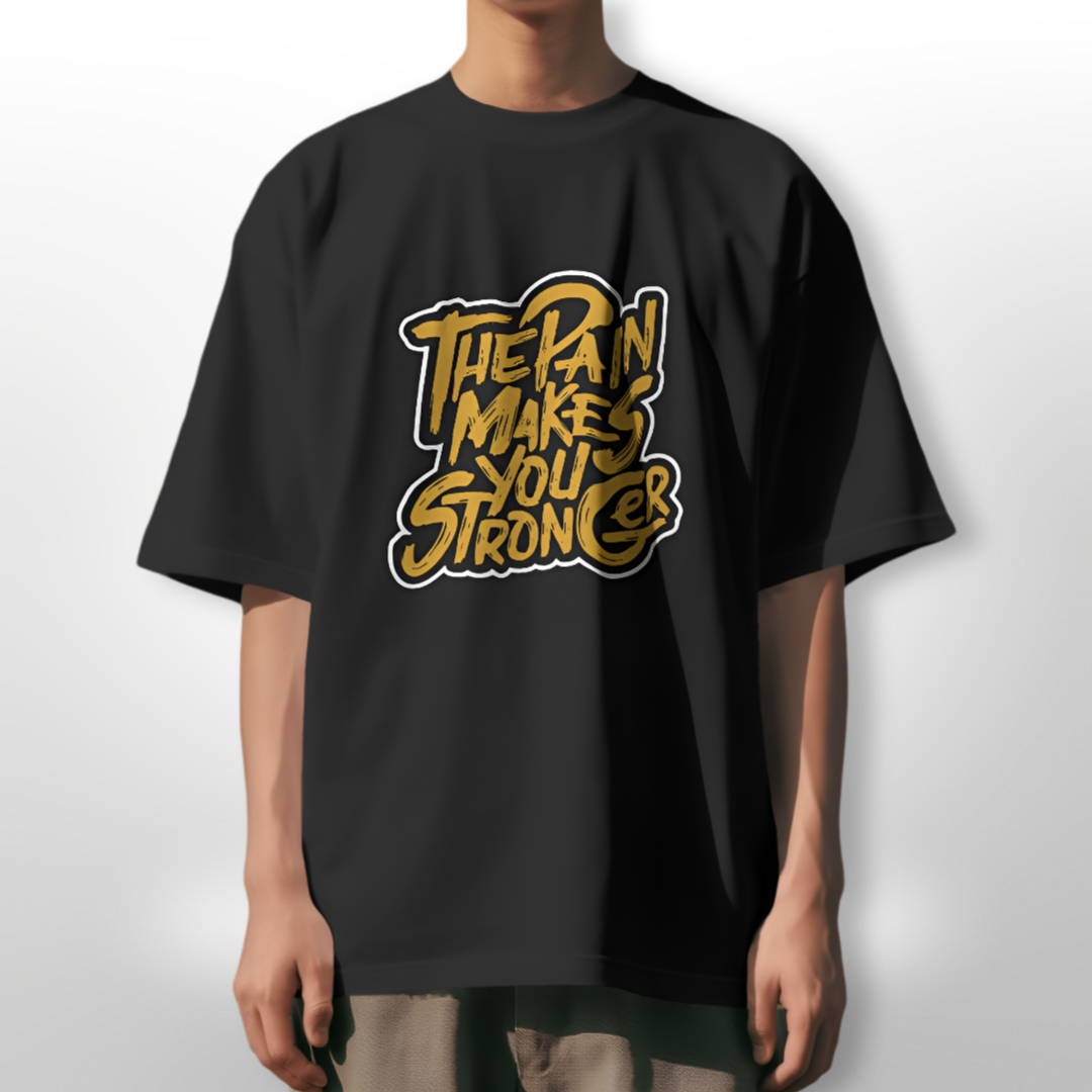 Model training in a gym wearing 'The Pain Makes You Stronger' oversized black T-shirt, demonstrating resilience.