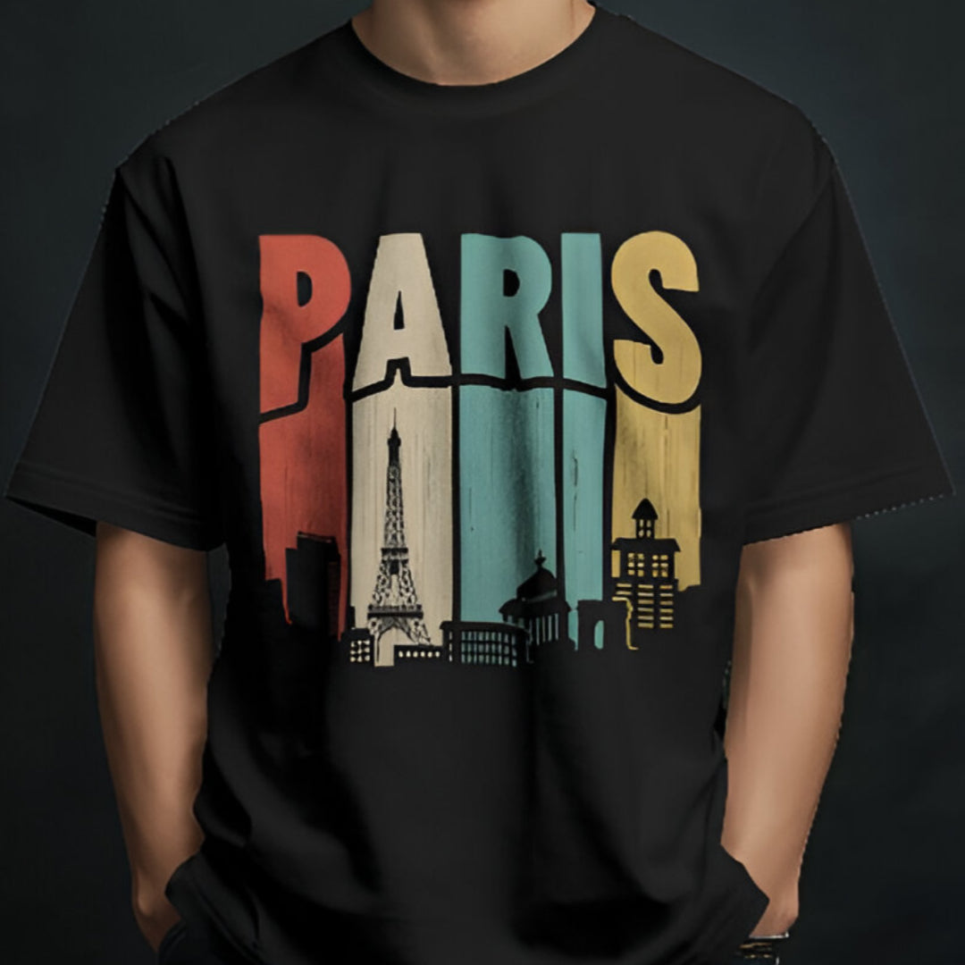 Model posing in chic PARIS oversized T-shirt, paired with white trousers for a contemporary look.